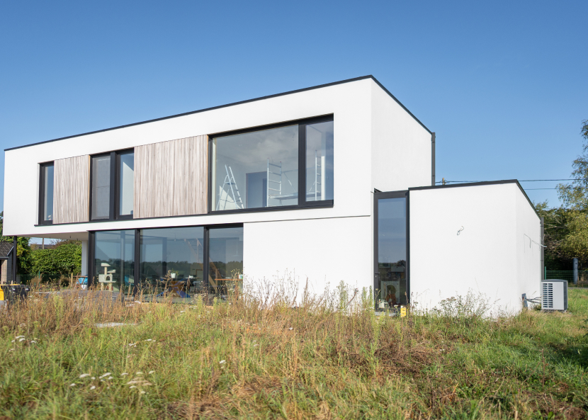 Une maison moderne à deux étages avec une façade recouverte d'un crépis sur isolant de couleur claire