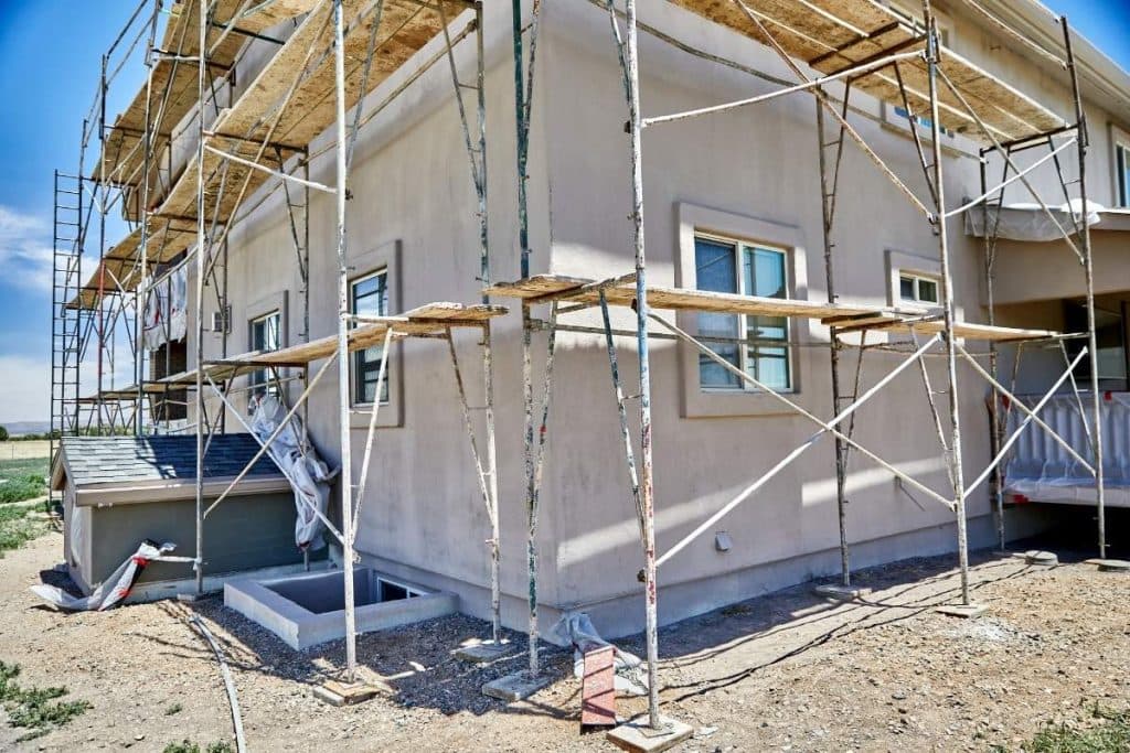Façade d'une maison en travaux avec du crépi de couleur claire