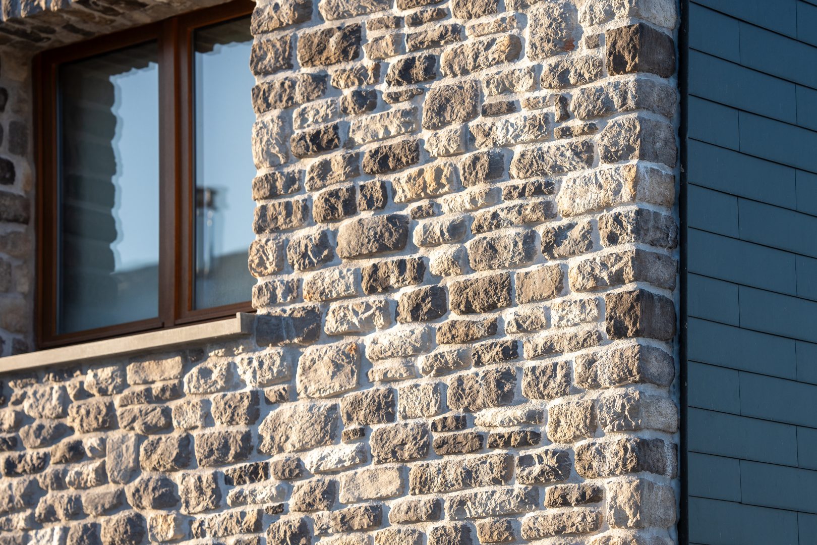 Façade d'une maison en pierres naturelles grises sur isolant