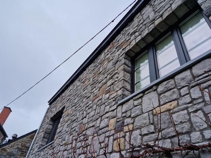Maison avec une façade en pierres naturelles de couleur grise et de tailles différentes après isolation
