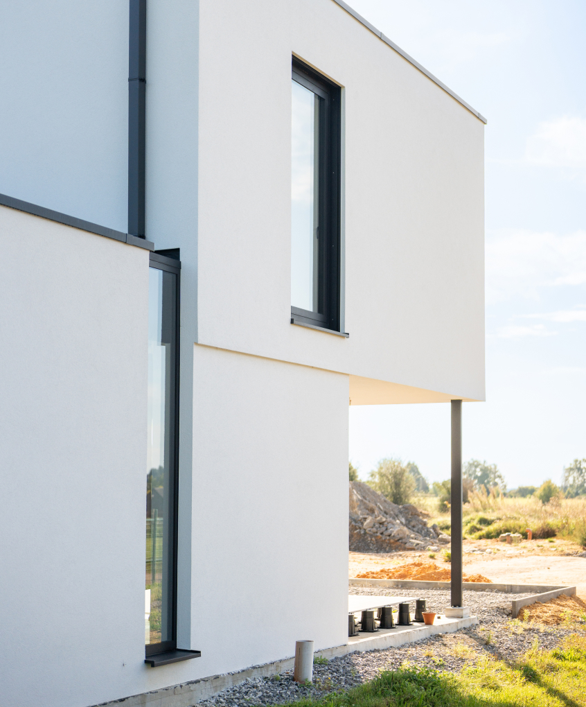 Maison moderne à l'architecture cubique avec une façade en crépi blanc sur isolant