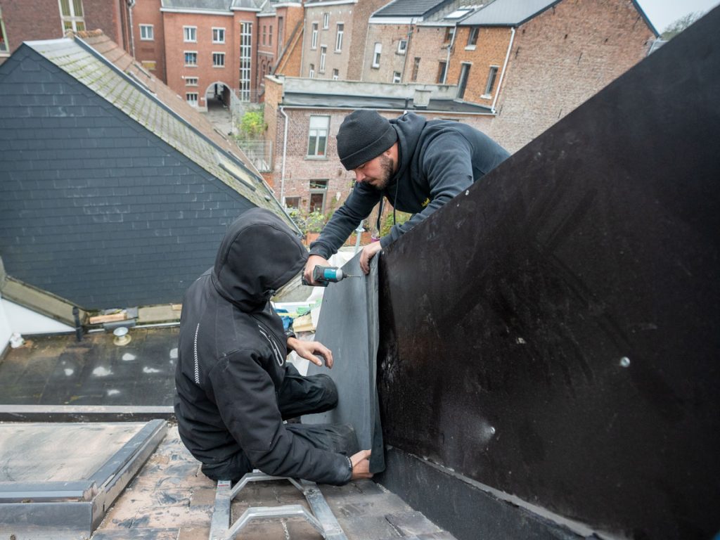 Deux hommes faisant une rénovation sur une toiture